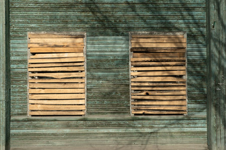 An old wooden house with boarded up windows. A symbol of abandonment and decline.の写真素材