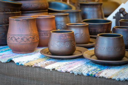 Traditional ceramics. Clay cups, jugs, plates and bowls on the counter of the master.