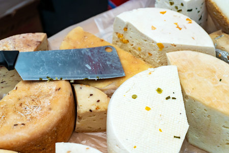 Sale of cheese. Heads of cheese lie on the counter. Large pieces of cheese for sale. Cheese shop....