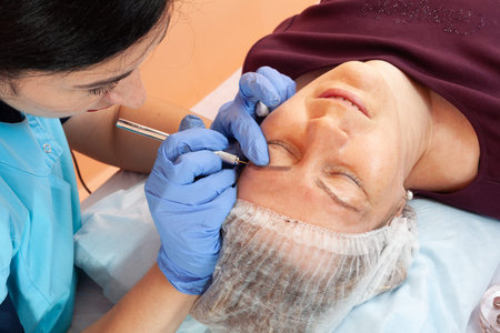 Permanent eyebrow makeup. A cosmetologist performs microblading. Eyebrow correction. Close-up....
