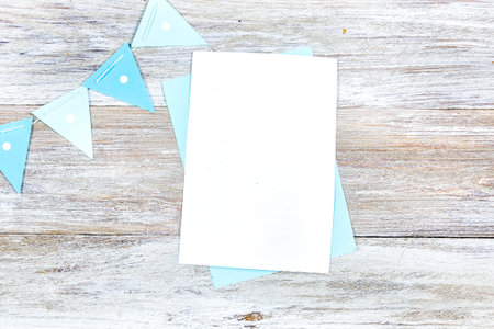 A 5x7-inch invitation card mockup on a wooden background with blue flag decorations, ideal for...
