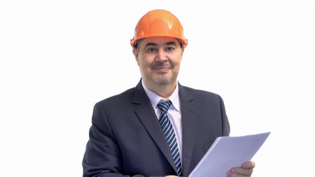 A construction engineer dressed in a suit and wearing a hard hat is smiling at the camera. The image is isolated on a white background.の写真素材