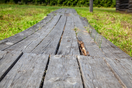 Close-up of old wooden plank walkways in a rural village, showing weathered boards and rustic construction details.の写真素材