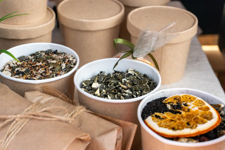 Various types of tea leaves are on display at the farmers' market, and samples of dried and cut tea are on display at the counter.の写真素材
