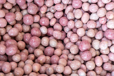 Close-up of yogurt glazed nuts displayed for sale at a local farmers market. Healthy sweet snack...