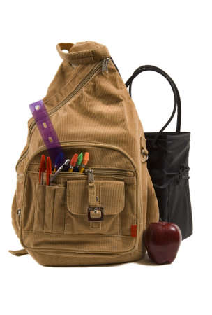 brown school back pack full of school supplies with paper, folders and pencils, courdoroy, and an appleの写真素材