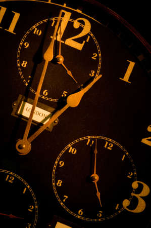 vintage clock with multiple faces depicting time in different parts of the world light painted with flashlight.の写真素材