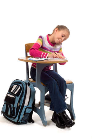 young girl concentrating on work, correcting mistake, erasing at school deskの写真素材
