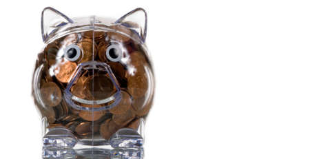 Clear plastic piggy bank stuffed full of penniesの写真素材