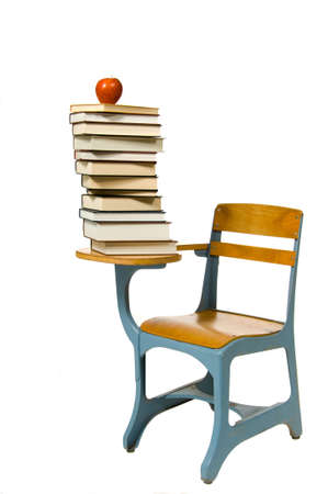 School desk on white with a huge stack of books and an appleの写真素材