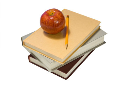 Several school books and an apple in front of and on white backgroundの写真素材