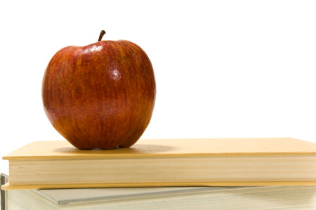 Several school books and an apple in front of and on white backgroundの写真素材