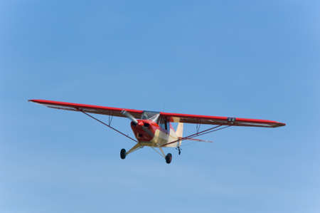 Small, single engine airplane against blue skyの写真素材