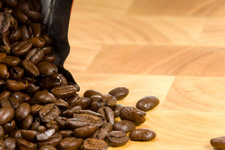 Whole coffee beans on wooden cutting boardの写真素材