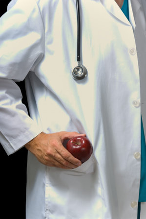 Doctor in lab coat pulling an apple out of his pocket