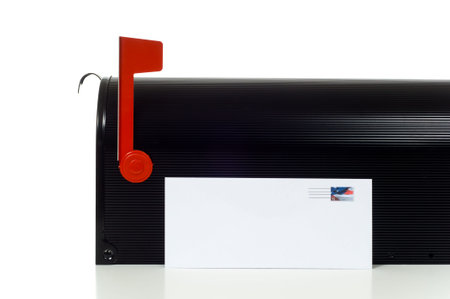 Blank envelope leaning against black mail box with the flag up on a white backgorund, add your own text or copy, stamp was created by photographer using one of his own stock images.  Stamp is fake.の写真素材
