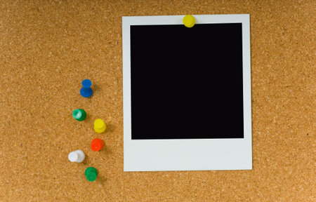 Poloroid picture with pushpins on corkboard bulletin board 