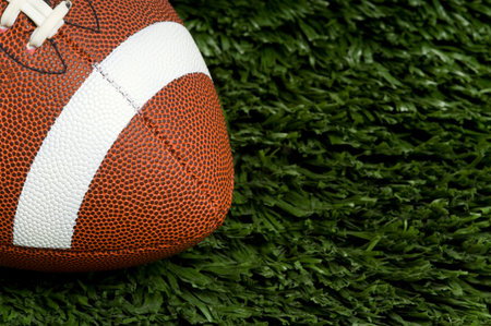 American football on green artificial grass field, copy space to the right