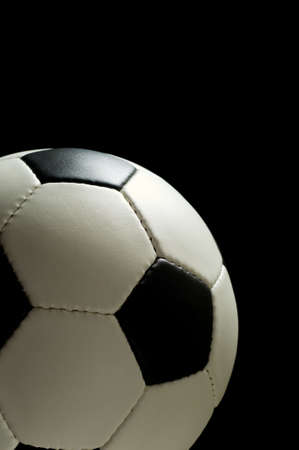 American soccer ball or European football on black background lit from the top with copy space to the right and above ballの写真素材