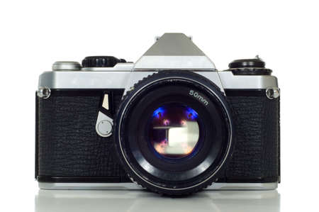 Vintage 35mm camera on white background with lens and reflection on the surface below the cameraの写真素材