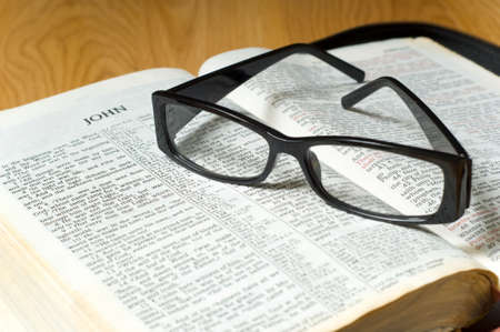 A pair of ladies reading glasses on top of a a Bible, religious studyの写真素材
