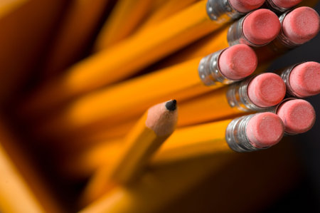 A holder full of yellow pencils with shallow depth of field, focus is on the tip of the pencil lead...