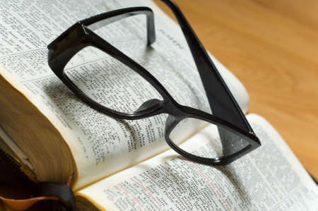 A pair of ladies reading glasses on top of a a Bible, religious studyの写真素材