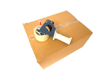 Brown, corrugated cardboard shipping box with packing tape on top on white background