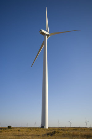 Energy producing wind turbines against a blue sky with copy space