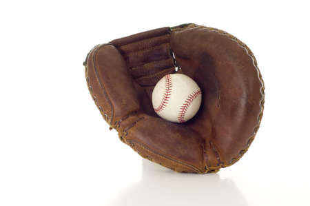 A brown leather baseball mitt with a white leather baseball on a white background with copy spaceの写真素材