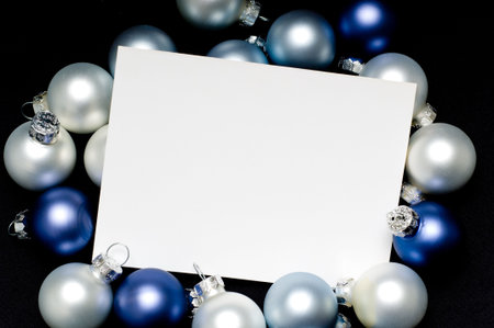 Notecard surrounded with Christmas balls with a blank white copy spaceの写真素材