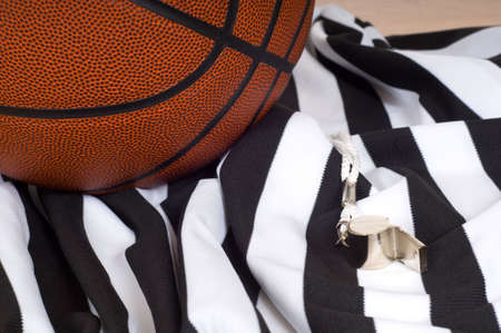 A basketball referees items including a ball, a striped jersey and a whistleの写真素材