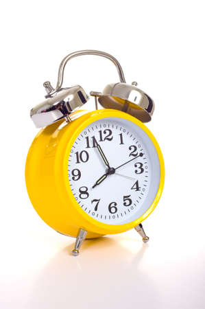 a vintage, antique yellow alarm clock on a white backgroundの写真素材