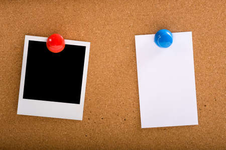 A photograph and a note on a corkbaord or bulletin board, held with oversized colorful push-pinsの写真素材