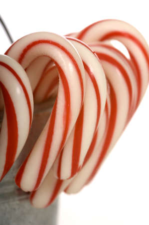 A silver bucket of Christmas time Candy Canes on a white background with copy spaceの写真素材