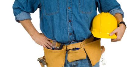 A construction worker on white background holding a hard hat and wearing a leather tool beltの写真素材