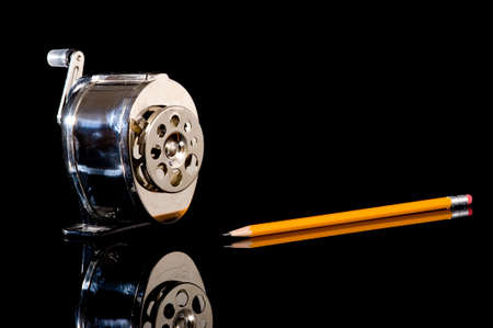 A pencil sharpener and a yellow pencil on a black background with copy spaceの写真素材