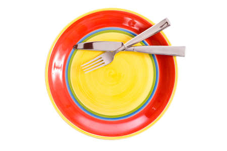 A brightly colored red, green and yellow dinner plate on a white background with silverware, dinnerware, or flatware.  With copy spaceの写真素材