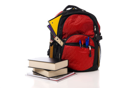 A red overflowing school backpack  or book bag with school books on a white backgroundの写真素材