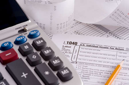 An adding machine or calculator with adding machine tape or paper and tax formsの写真素材