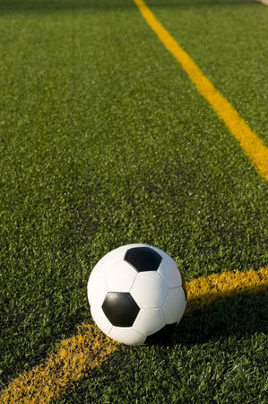 A soccer ball or football on a soccer field positioned for a corner kick