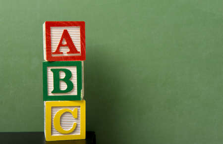 ABC blocks in front of a green chalkboard with copy spaceの写真素材