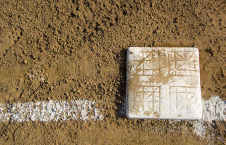 Empty base on chalked baseball field, symbol of accomplishment, with copy spaceの写真素材
