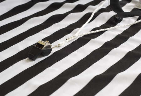 A referee striped shirt with a whistle, sports equipment, authority conceptの写真素材