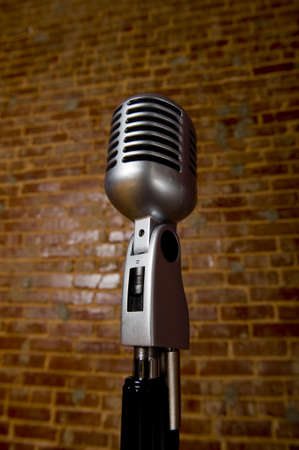 A vintage microphone in front of a brick wall の写真素材