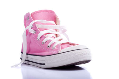 A pair of pink vintage styled canvas basketball shoes or sneakers on a white background with copy spaceの写真素材