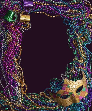 A group of mardi gras beads and mask making a frame with copy space on a purple backgroundの写真素材