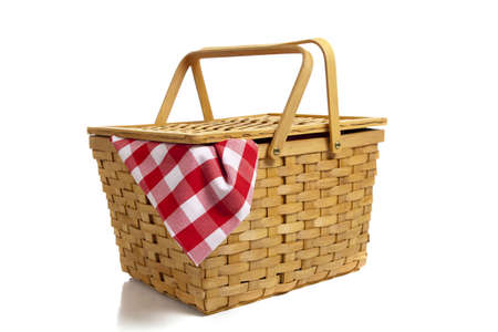 A wicker picnic basket with a red gingham cloth on a white backgroundの写真素材