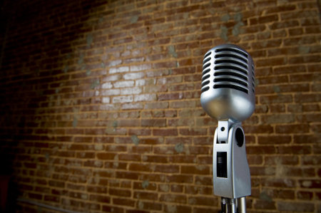 A vintage looking microphone in front of an old brick wall with copy spaceの写真素材