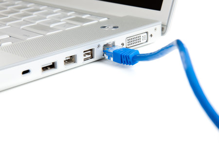 A blue cable plugged into a port on a portable computer with copy space